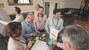 | `Aftermovie.jpg` | Groupe de professionnels en atelier collaboratif (post-its, badge Marivaux) | `Aftermovie d'&eacute;v&eacute;nement corporate : participants en atelier collaboratif avec post-its, production vid&eacute;o d'entreprise` |