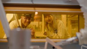 | `kapla pinces.jpg` | Deux techniciens Orano en combinaison jaune observant des &eacute;quipements derri&egrave;re une vitre | `Techniciens Orano en &eacute;quipement de protection nucl&eacute;aire observant des &eacute;quipements radioactifs, tournage dans une installation nucl&eacute;aire s&eacute;curis&eacute;e` |